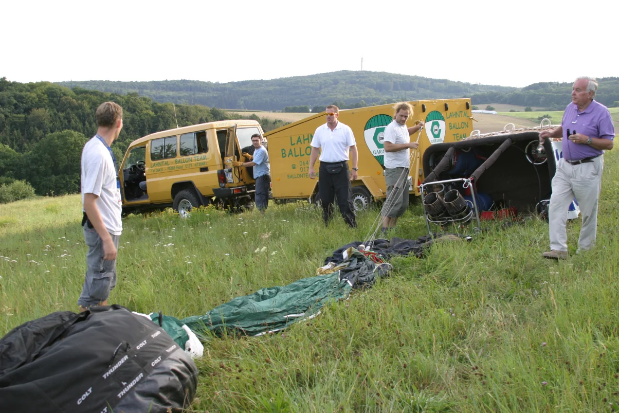 Das Lahntal-Ballonteam und seine Gäste bereiten auf einer Wiese gemeinsam den Ballonkorb vor